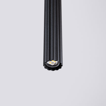 Vue détaillée de la base du tube cannelé noir et de son ouverture pour ampoule.