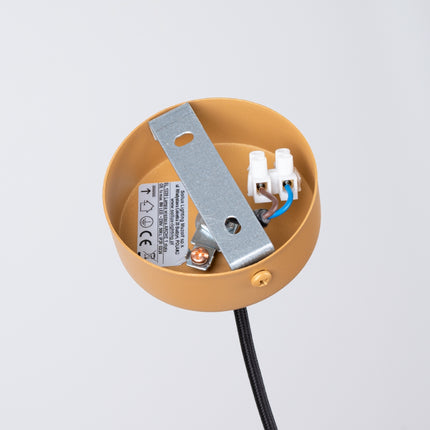 Gros plan sur les cannelures du tube en acier doré de la suspension design Sovala.