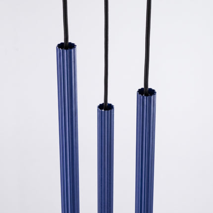 Suspension Cannelée 3 Lumières acier bleu outremer sur fond coloré, vue de trois quarts