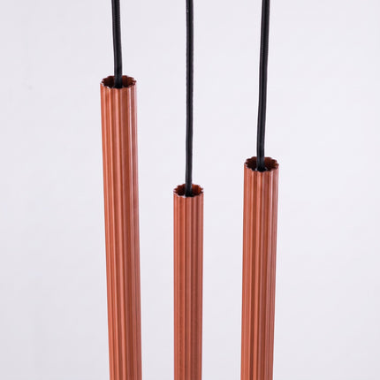 Suspension Cannelée 3 Lumières acier ocre rouge sur fond coloré, vue de trois quarts
