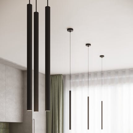 Suspension cannelée noire 3 lumières dans un salon contemporain, lumière douce et intérieur moderne.