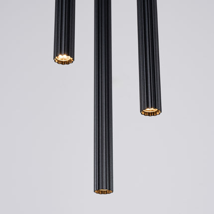 Détail texturé des stries des tubes cannelés noirs, sous un éclairage naturel.