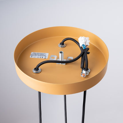 Gros plan sur les cannelures des tubes en acier doré de la suspension design Sovala.