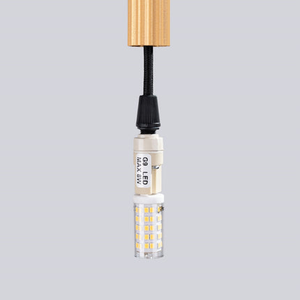 Gros plan sur la finition dorée soyeuse de la suspension cannelée 3 lumières Sovala.