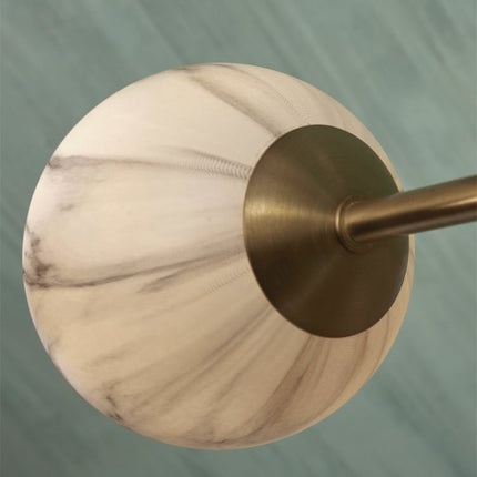 Vue de face de la suspension Carrara 6 globes marbre et or, bras dorés déployés