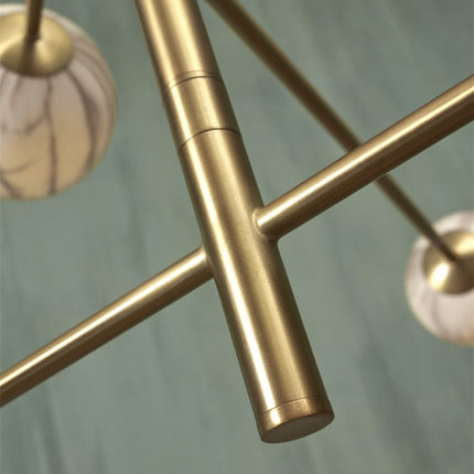 Suspension Carrara 6 globes marbre et or dans un salon spacieux, lumière diffuse et chaleureuse