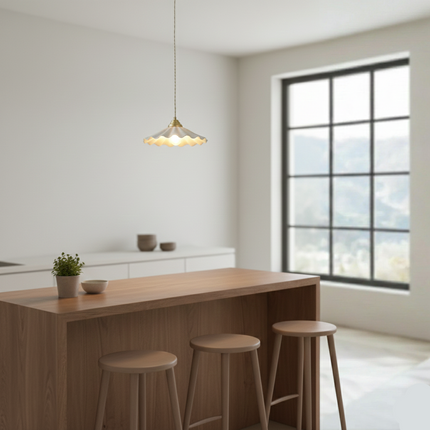 Suspension céramique ondulée au-dessus d'un îlot de cuisine en bois et tabourets clairs