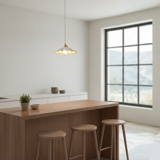 Suspension céramique ondulée au-dessus d'un îlot de cuisine en bois et tabourets clairs