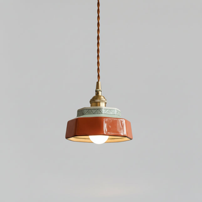 Suspension en céramique peinte à la main, coloris terracotta et douille laiton, sur fond gris épuré