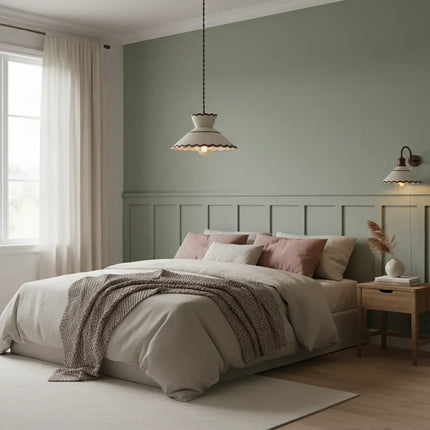 Suspension en céramique ondulée dans une chambre au mur vert sauge et linge naturel