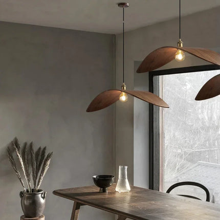 Deux suspensions chapeau ondulé en bois au-dessus d'une table à manger