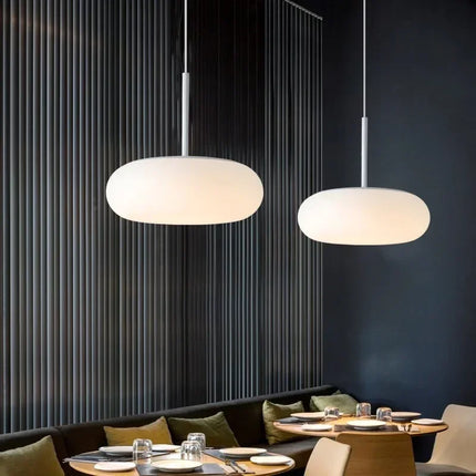 Suspension circulaire acrylique nordique blanche au-dessus d'un îlot de cuisine