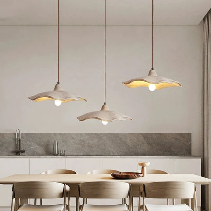Suspension circulaire en béton éclairant un salon d'une lumière douce