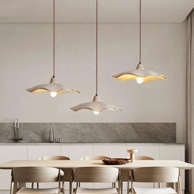 Suspension circulaire en béton éclairant un salon d'une lumière douce