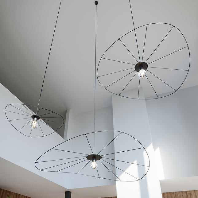 Suspensions circulaires filaires noires vues en contre-plongée au plafond d'un grand volume