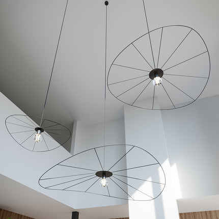 Suspensions circulaires filaires noires vues en contre-plongée au plafond d'un intérieur design