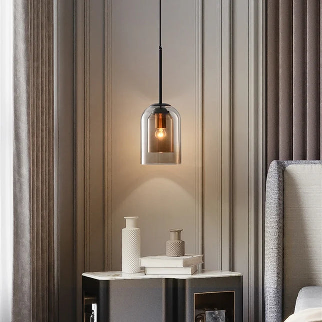 Suspension cloche en double verre marron au-dessus d'une table de chevet dans une chambre