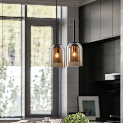 Deux suspensions cloche en double verre marron devant une fenêtre dans une cuisine moderne
