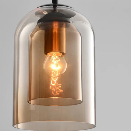 Gros plan sur la double paroi de verre marron ambré et l'ampoule filament de la suspension