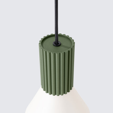 suspension cône beige à fût cannelé vert olive, vue sur fond coloré