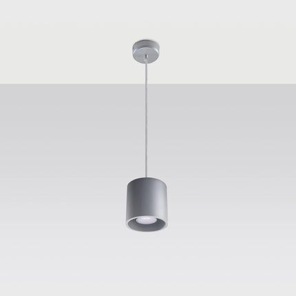 Suspension cylindrique grise au-dessus d'une table de salle à manger