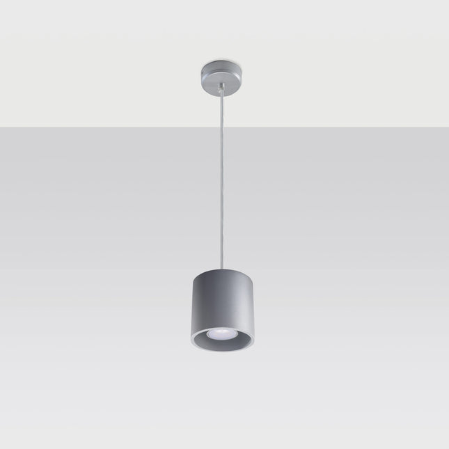 Suspension cylindrique grise au-dessus d'une table de salle à manger