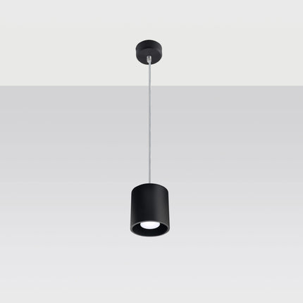 Suspension cylindrique noire au-dessus d'une table de salle à manger