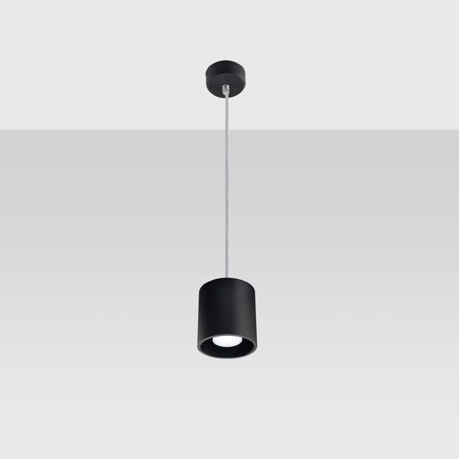 Suspension cylindrique noire au-dessus d'une table de salle à manger