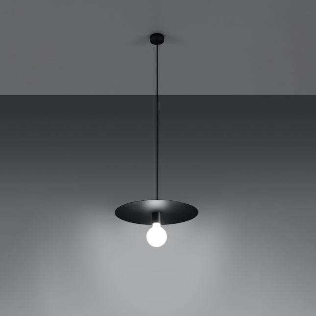 Suspension Flavio en acier noir suspendue sur fond gris, ampoule allumée sous le disque