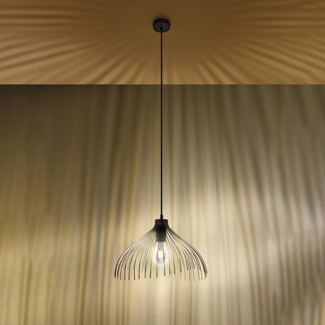 Suspension Fleur noire allumee diffusant une lumiere chaude ambree sur un mur et un plafond