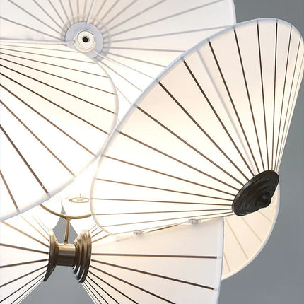 Détail des plis rayonnants du tissu blanc et de la structure métallique de la suspension