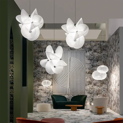 Trois suspensions fleur en tissu blanc au-dessus d'un salon scandinave aux tons verts