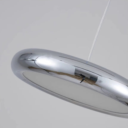 Détail du dessous d'une suspension galet chromée montrant le diffuseur lumineux et la coque miroir