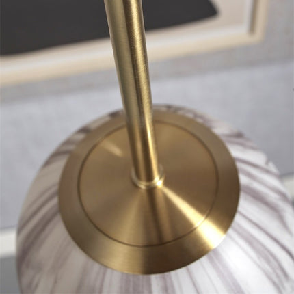 Détail de la fixation en métal doré reliant la tige au globe en verre effet marbre