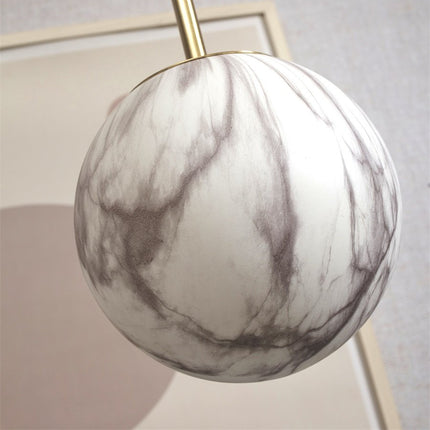 Gros plan sur le globe en verre effet marbre blanc et gris de la suspension Carrara
