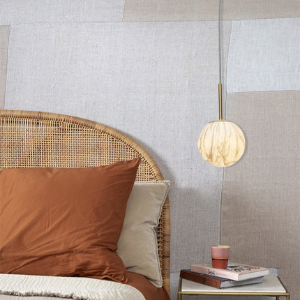 Suspension Carrara en verre effet marbre au-dessus d'une table de chevet dans une chambre au style naturel