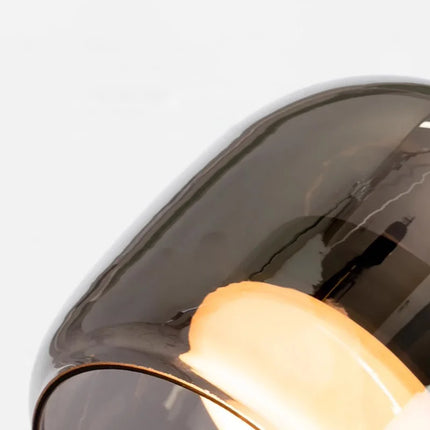 Gros plan sur le verre fumé et le diffuseur opale de la suspension globe
