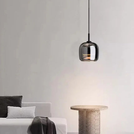 Suspension globe en verre fumé au-dessus d'un guéridon en travertin dans un salon épuré