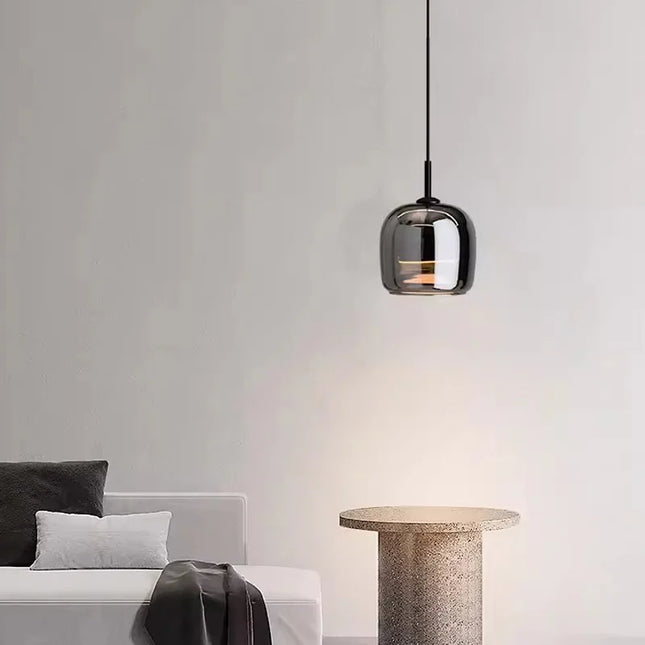 Suspension globe en verre fumé au-dessus d'un guéridon en travertin dans un salon épuré