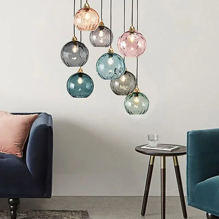 Suspension grappe de globes en verre soufflé multicolore au-dessus d'un salon au canapé bleu