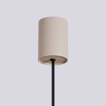 Suspension Halo 1 taupe installée au-dessus d'une table à manger, ambiance chaleureuse