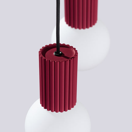 Suspension Halo 2 globes en grappe bordeaux sur fond coloré, vue de trois quarts