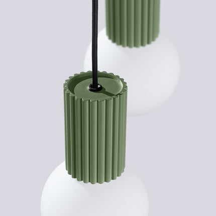 Suspension Halo 2 globes en grappe vert olive sur fond coloré, vue de trois quarts