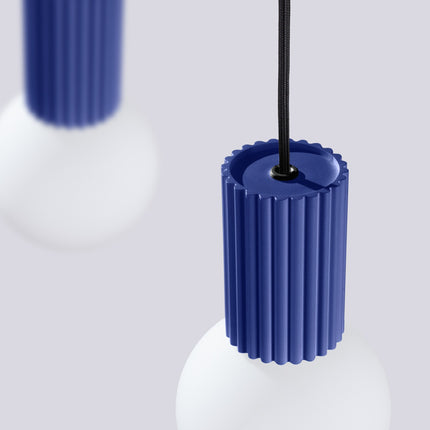 Suspension Halo 2 globes sur barre outremer sur fond coloré, vue de trois quarts