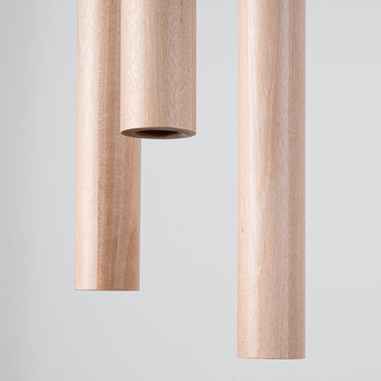 Gros plan sur l'embout d'un tube en bois naturel de la suspension Halo, grain et texture du bois visibles