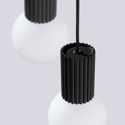 Suspension Halo 3P Noire, luminaire 3 globes verre opalin et aluminium noir mat nervuré, vue de trois quarts