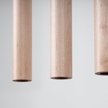 Gros plan sur l'embout d'un tube en bois naturel de la suspension Halo, grain et texture du bois visibles