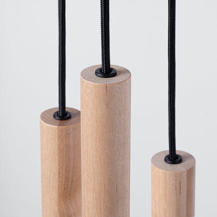 Gros plan sur l'embout d'un tube en bois naturel de la suspension Halo, grain et texture du bois visibles