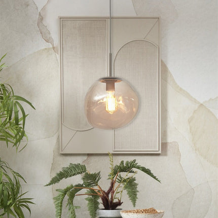 Suspension Helsinki verre ambre suspendue devant un panneau mural beige texturé, ambiance chaleureuse
