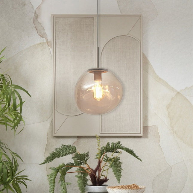 Suspension Helsinki verre ambre suspendue devant un panneau mural beige texturé, ambiance chaleureuse